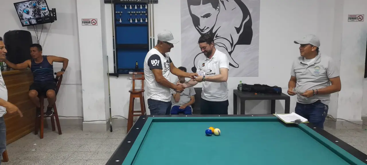 Entrega de un reconocimiento a un jugador frente a la mesa de billar