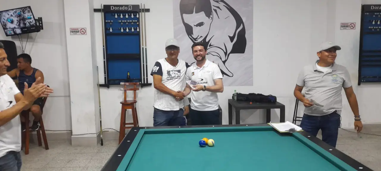 Jugador premiado posa con su reconocimiento junto a un organizador