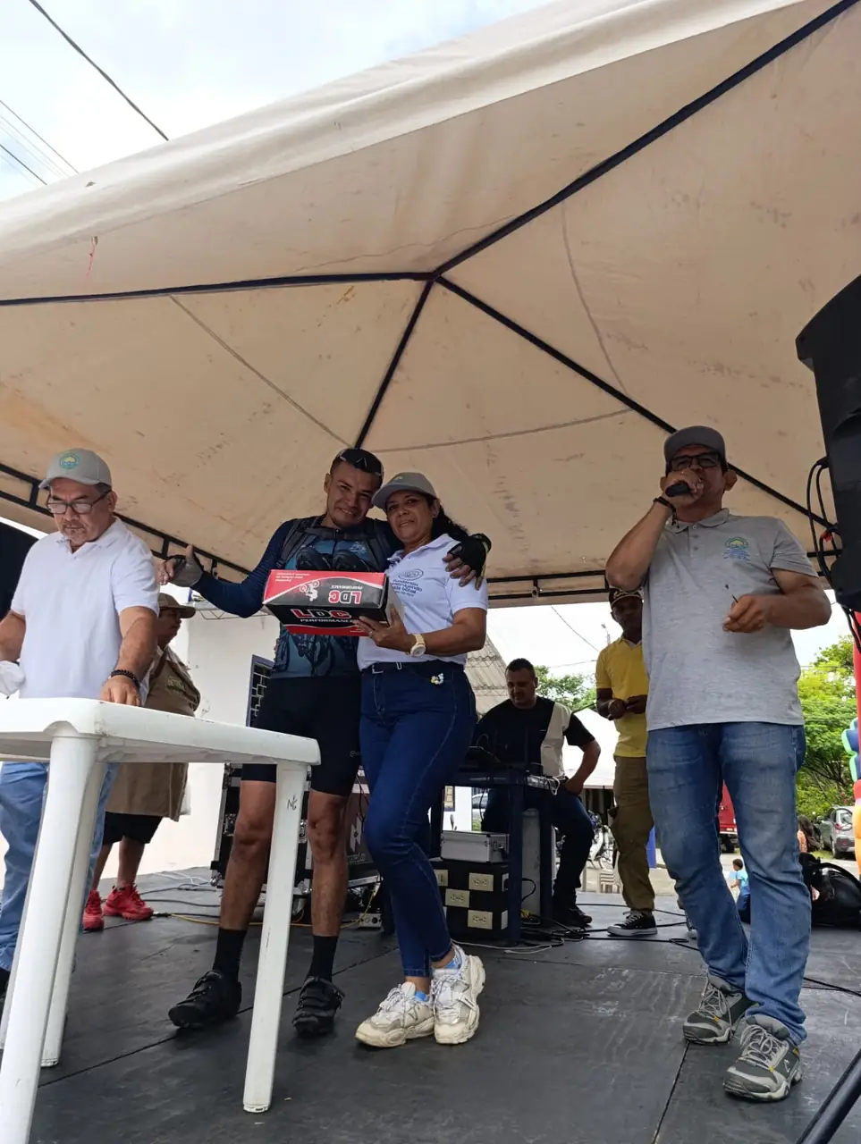 Premiación en tarima: un ciclista recibe su premio de manos de la organización