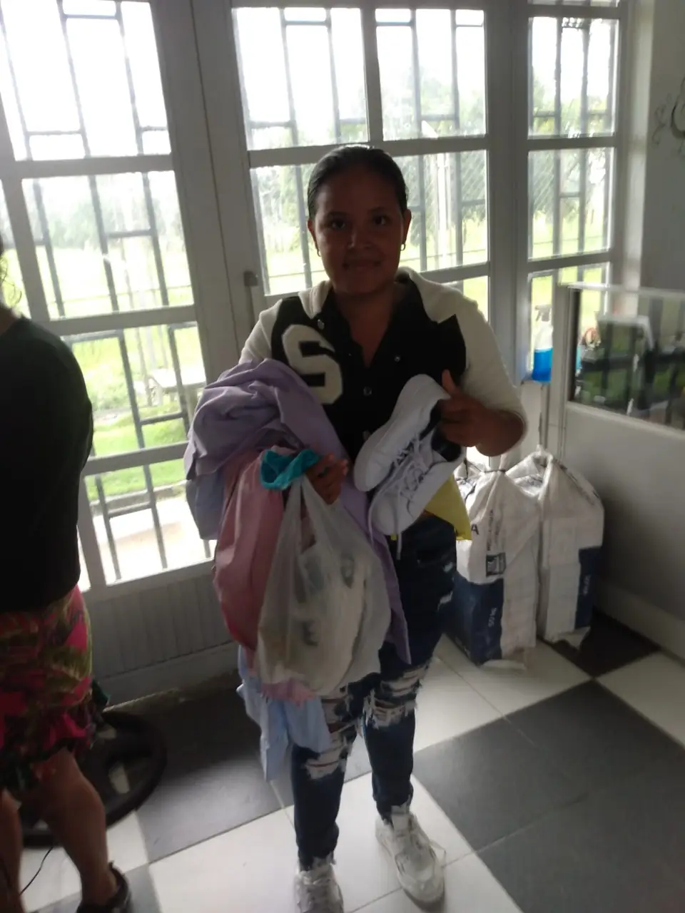 Una mujer sale con las prendas de vestir y el calzado que recibió